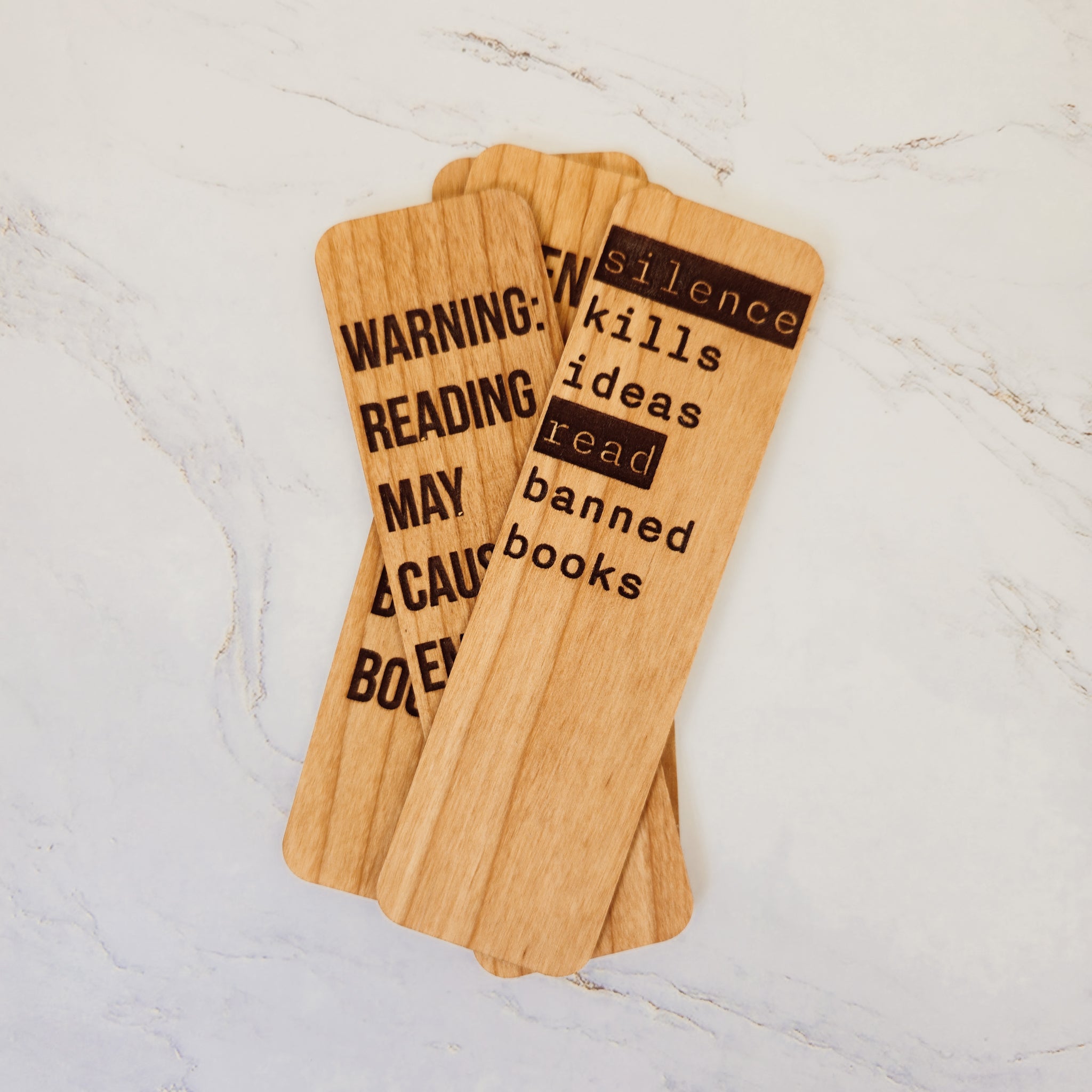 Laser-engraved wooden bookmarks by PRWMade in Cherry and Maple with witty literary designs