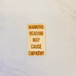 Maple wood sticker, natural finish, laser-engraved with the phrase Reading causes empathy in clear script.