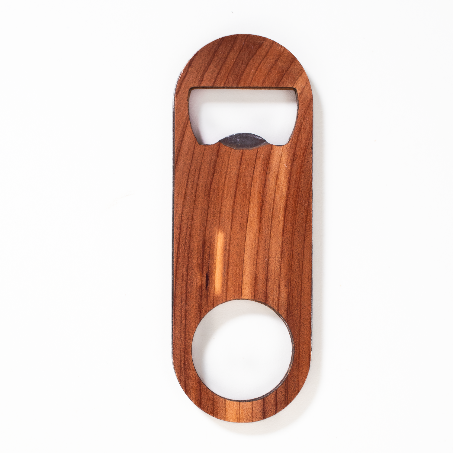 Handcrafted cedar wood oval bottle opener with metal edge, large circular cutout at base. Laser-engraved, smooth finish.