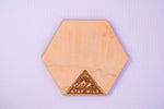 Hexagonal wooden coaster with 'Stay Wild' design on a light purple background