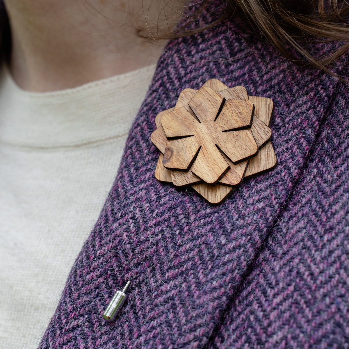 Wooden brooch on a purple textured fabric