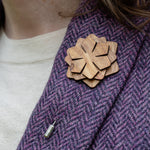 Wooden brooch on a purple textured fabric