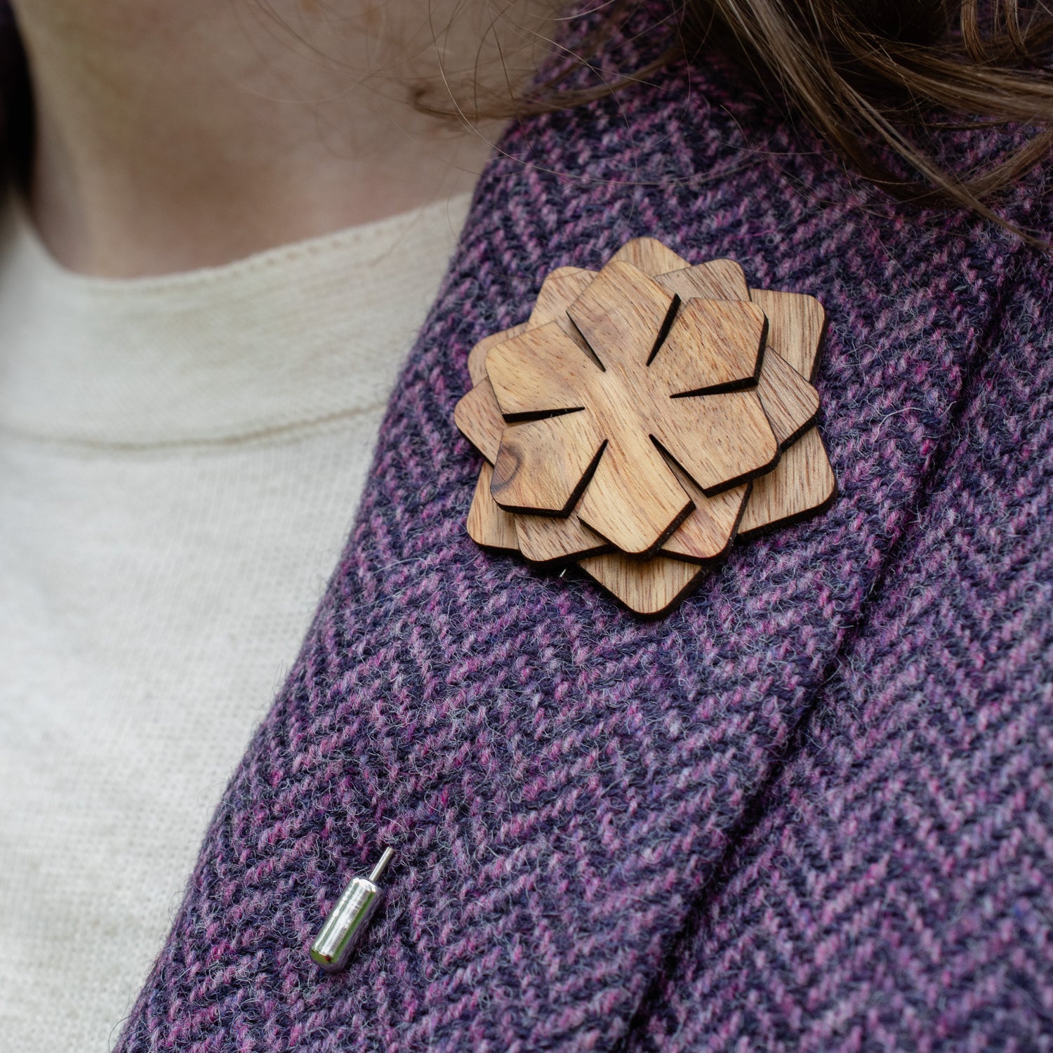Wooden brooch on a purple textured fabric