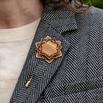 Wooden brooch on a person wearing a patterned coat