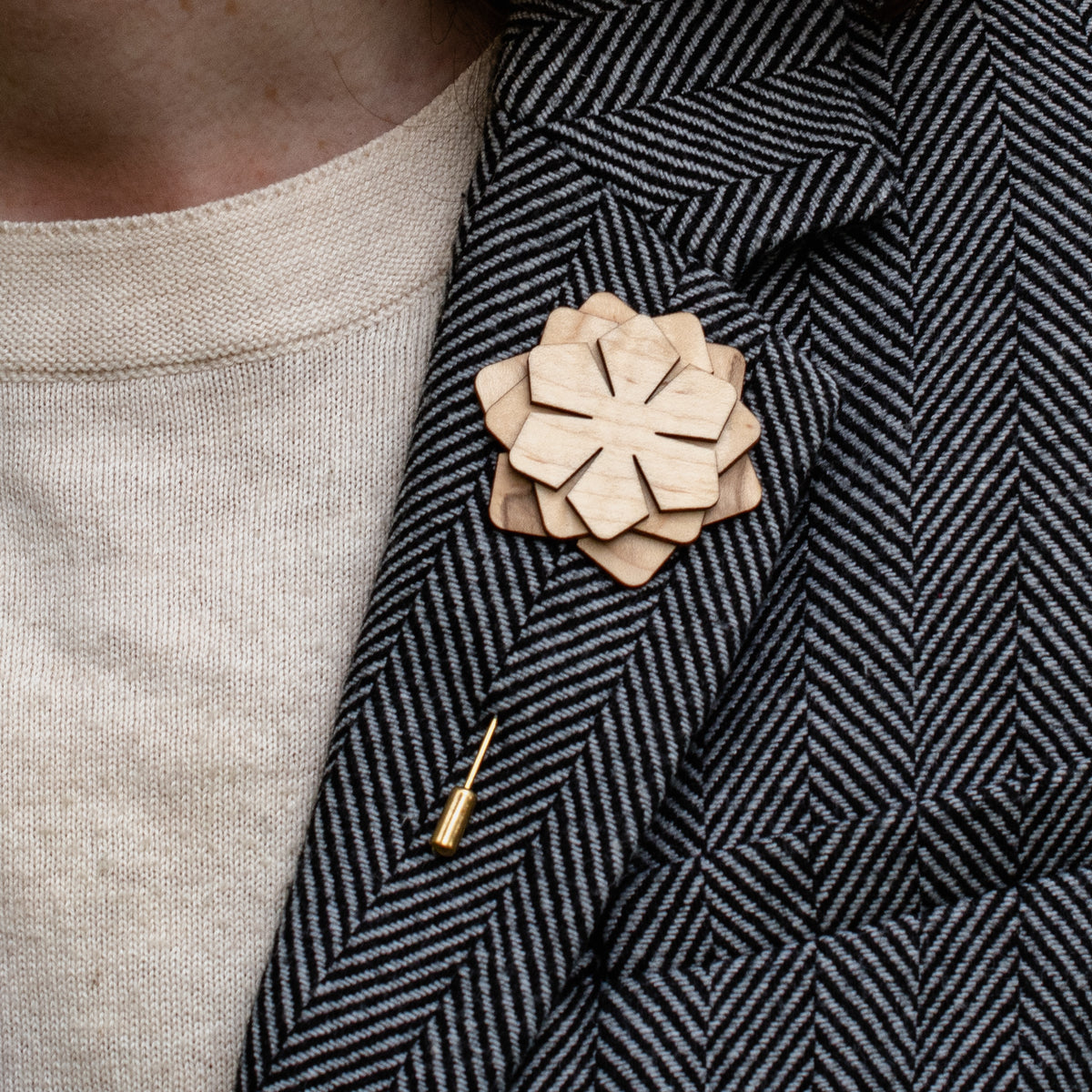 Wooden flower lapel pin on a textured blazer