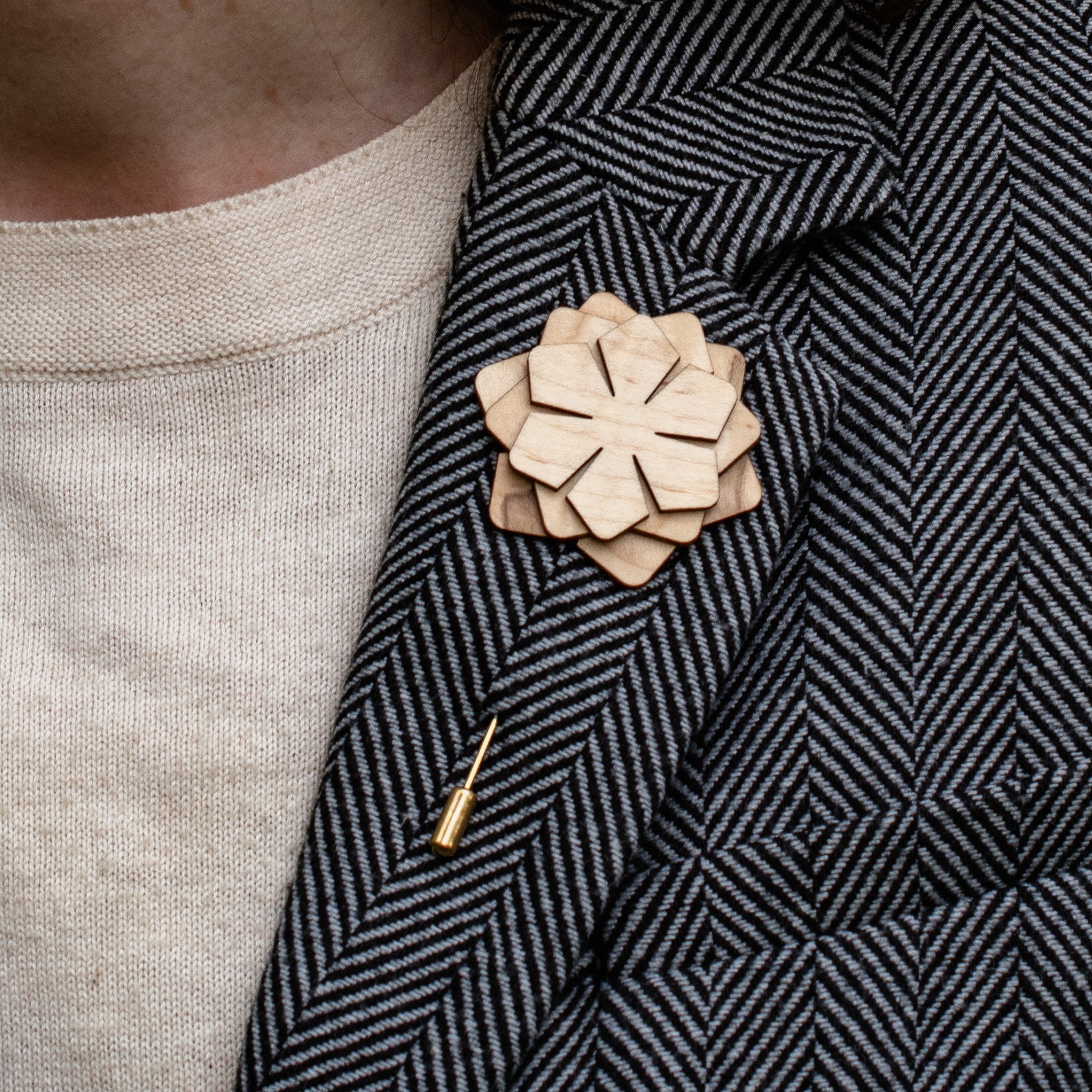Wooden flower lapel pin on a textured blazer