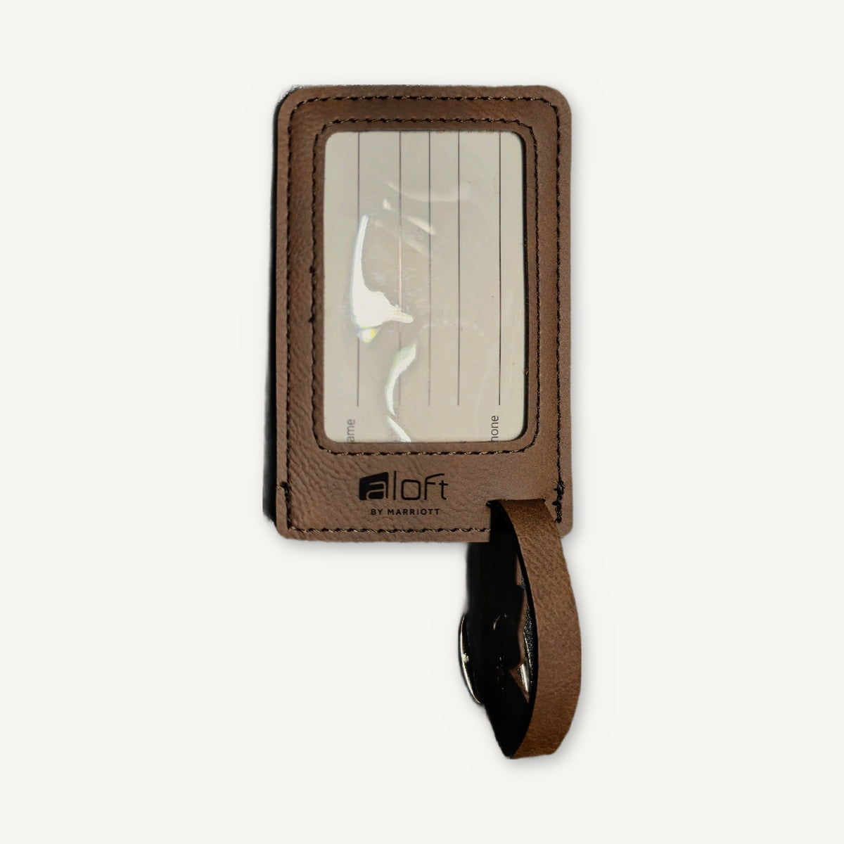 Dark brown leatherette luggage tag, front, with a clear ID window and a laser-engraved hotel logo