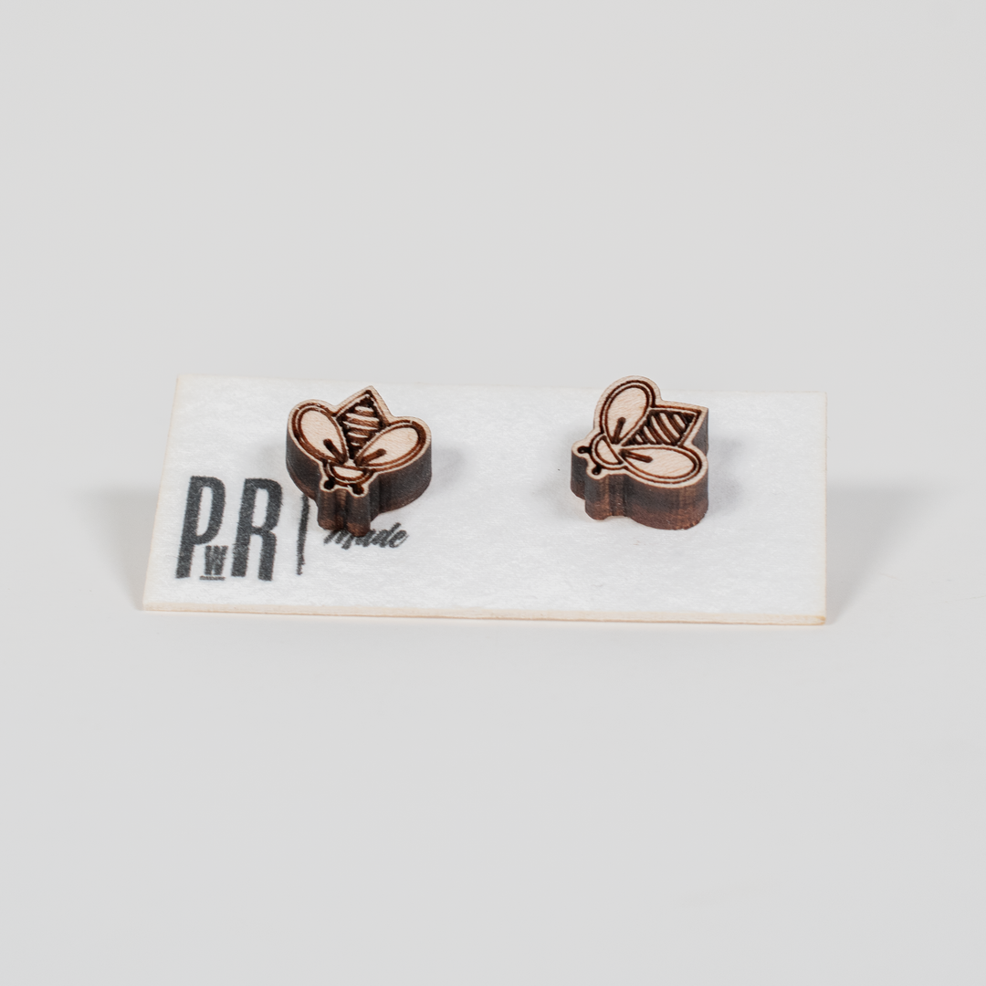 Handcrafted wooden stud earrings with geometric engraving, natural finish, displayed on a white PRW Made logo card.