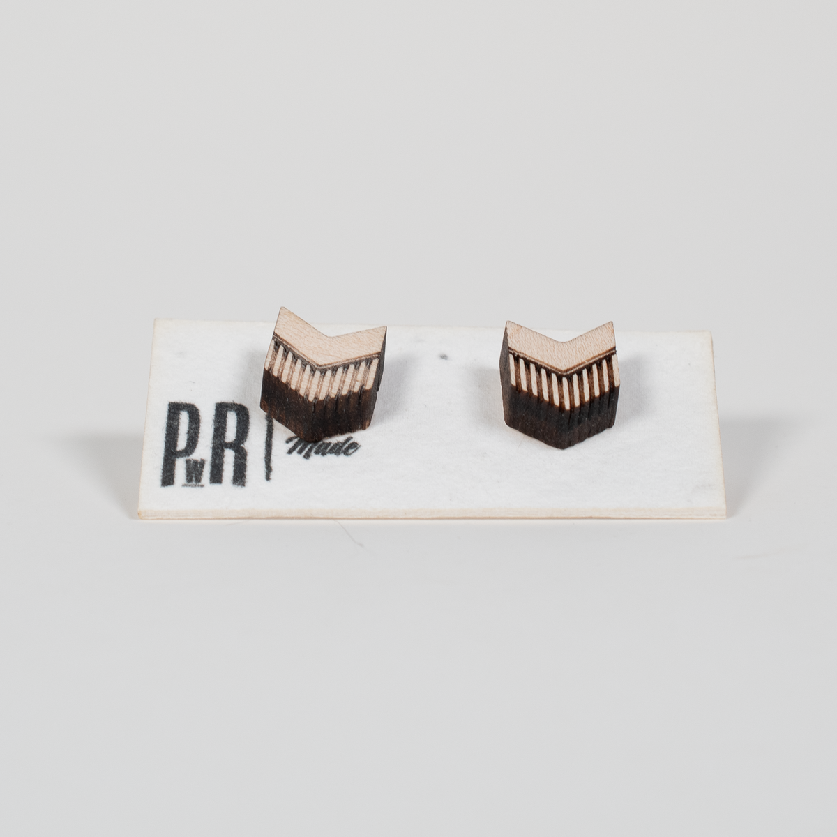 Maple wood stud earrings with engraved geometric chevron pattern, light natural finish, displayed on PRW Made branded card.