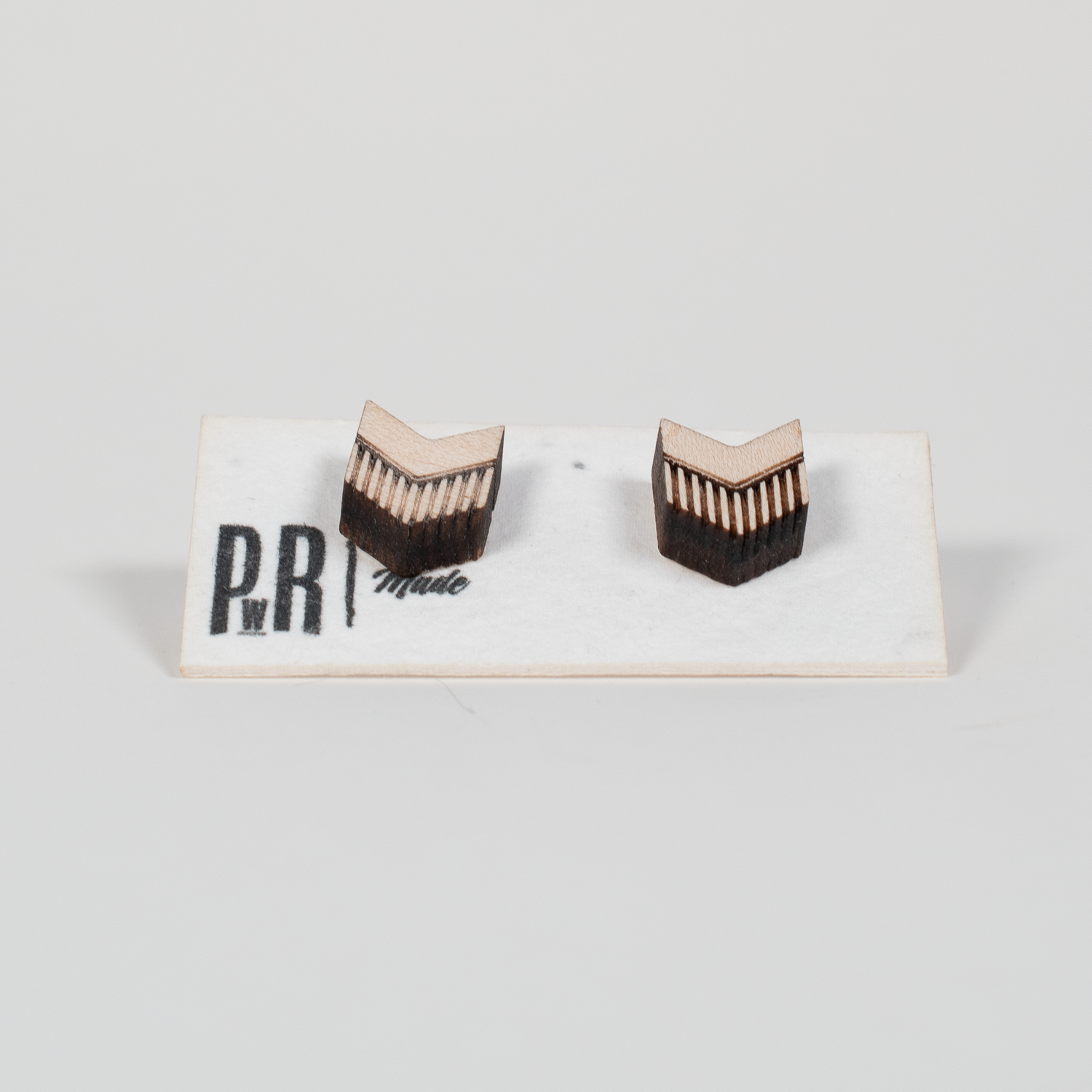 Maple wood stud earrings with engraved geometric chevron pattern, light natural finish, displayed on PRW Made branded card.