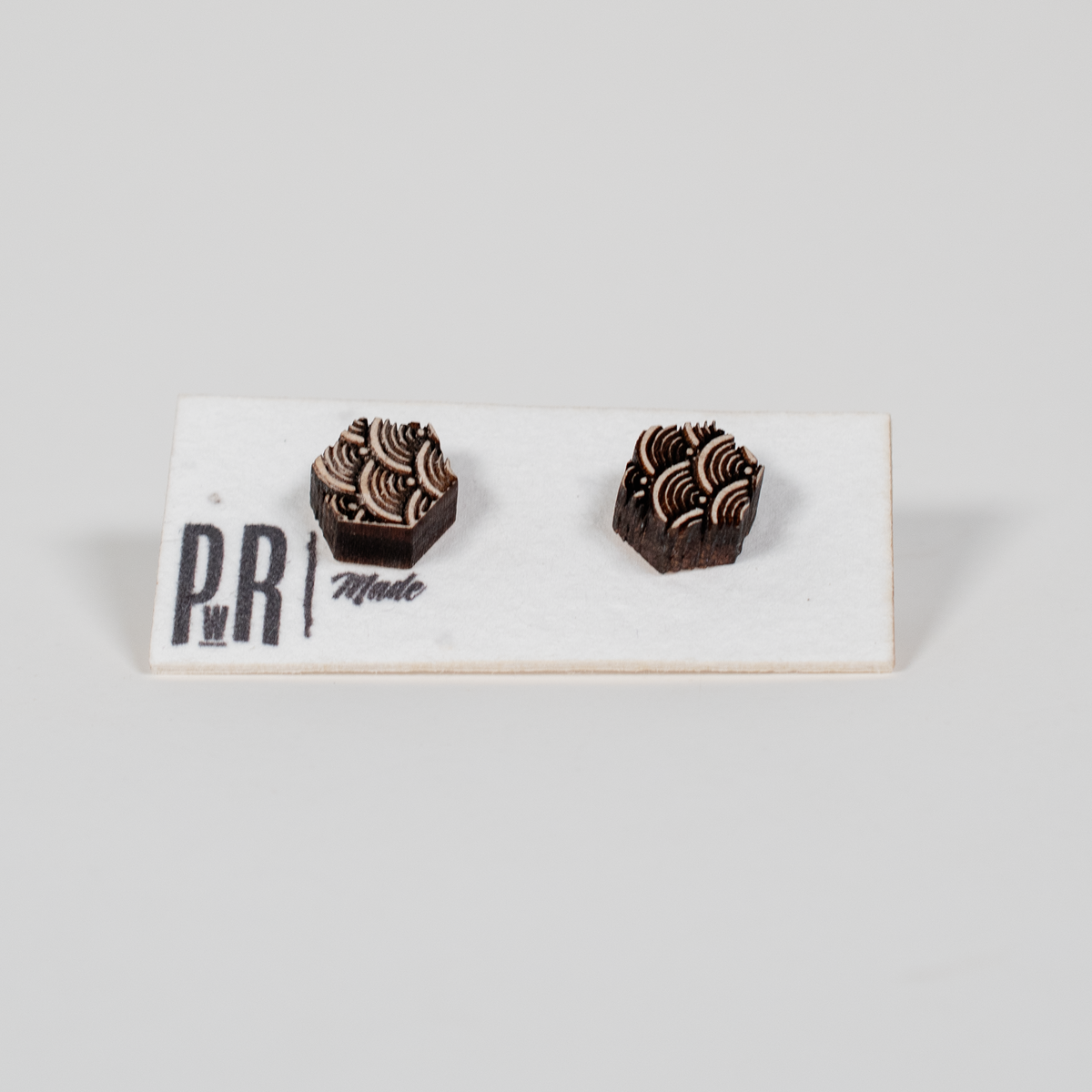 Geometric wood stud earrings with detailed laser-engraved patterns, natural finish, displayed on a white PRW Made card.