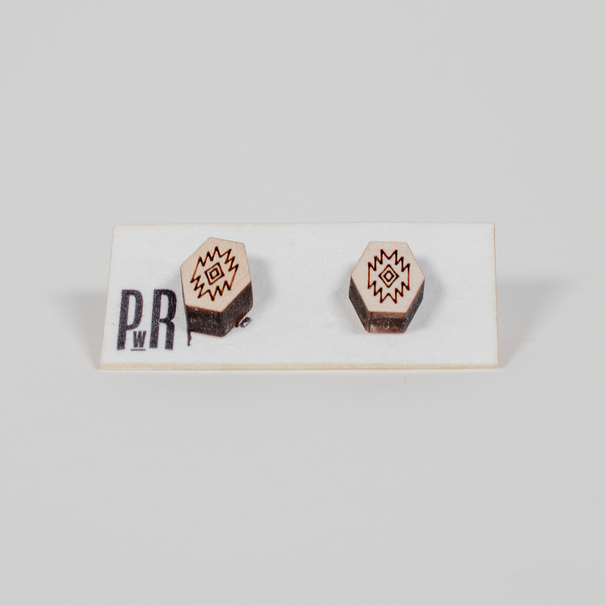 Hexagonal wood stud earrings with black geometric engraving, hypoallergenic posts, displayed on a PRW Made white card.