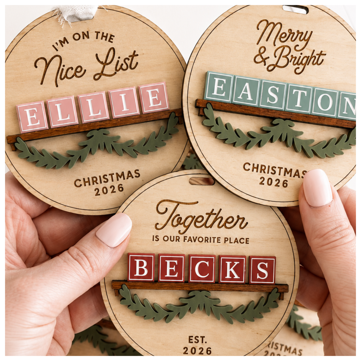 Personalized name Christmas ornaments in Baltic birch with colored block-letter name tiles and engraved holiday phrases