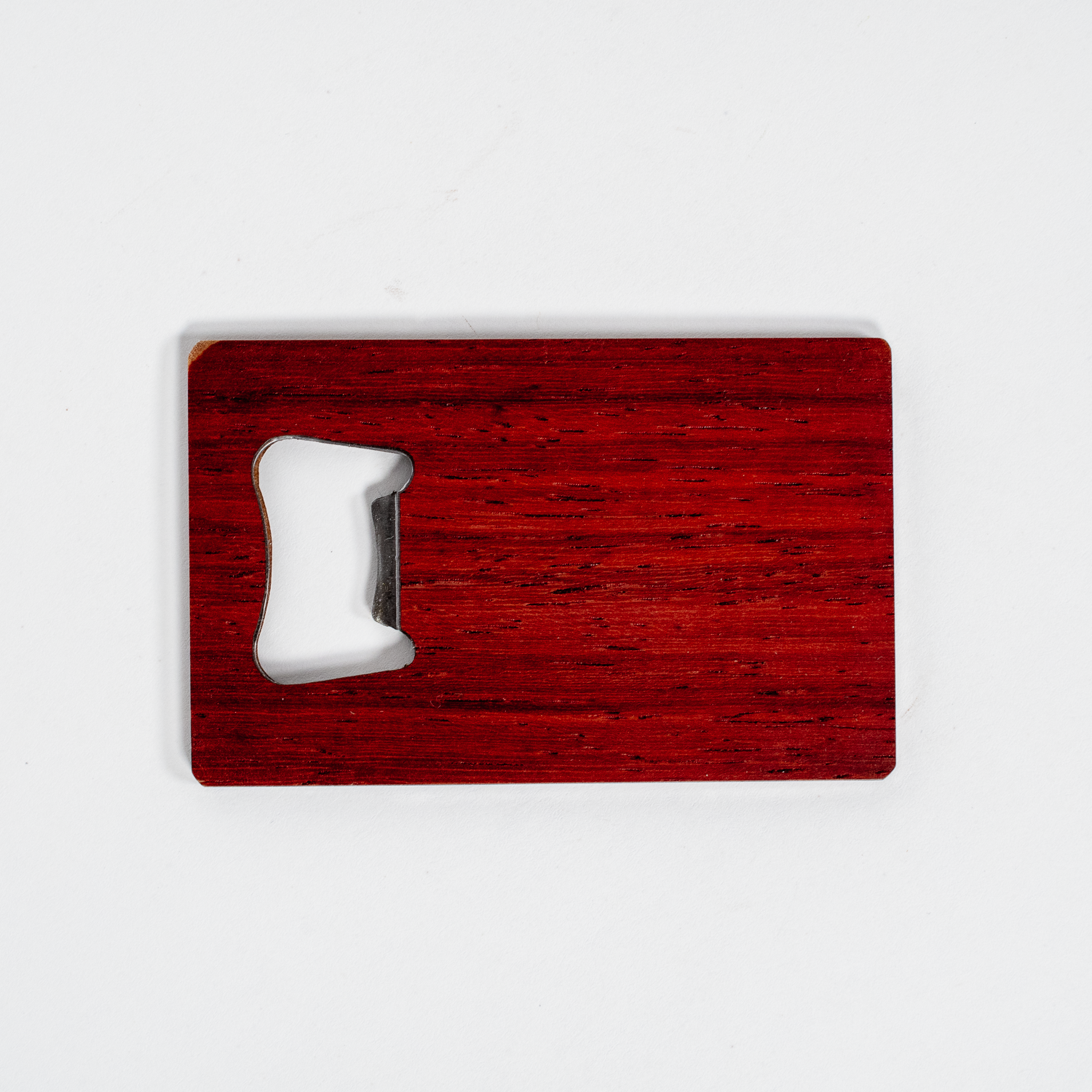 Paduk wood veneer wallet bottle opener with smooth finish, slim rectangular shape, rich reddish tone, fits in a wallet.