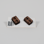 Pair of small laser-engraved wood stud earrings with geometric cassette tape design, natural finish, displayed on branded card.