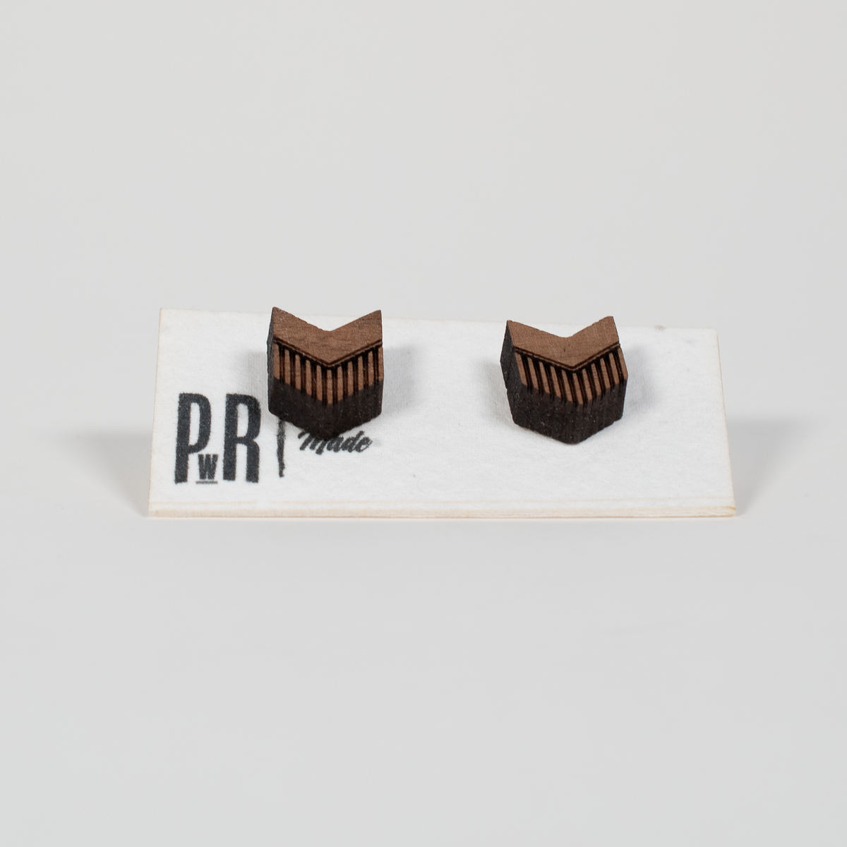 Walnut wood stud earrings with geometric laser-engraved designs, matte finish, presented on a white PRW Made logo card.