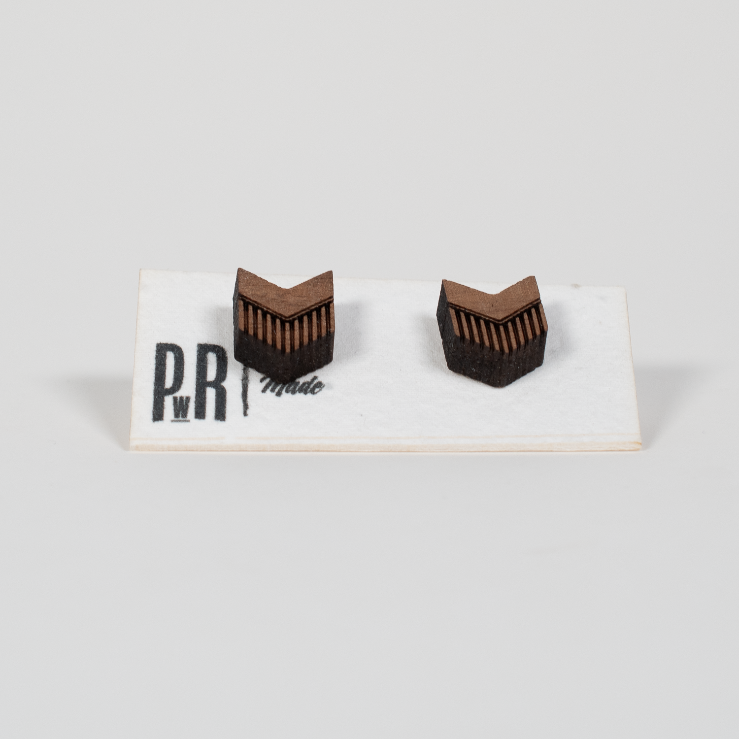 Walnut wood stud earrings with geometric laser-engraved designs, matte finish, presented on a white PRW Made logo card.
