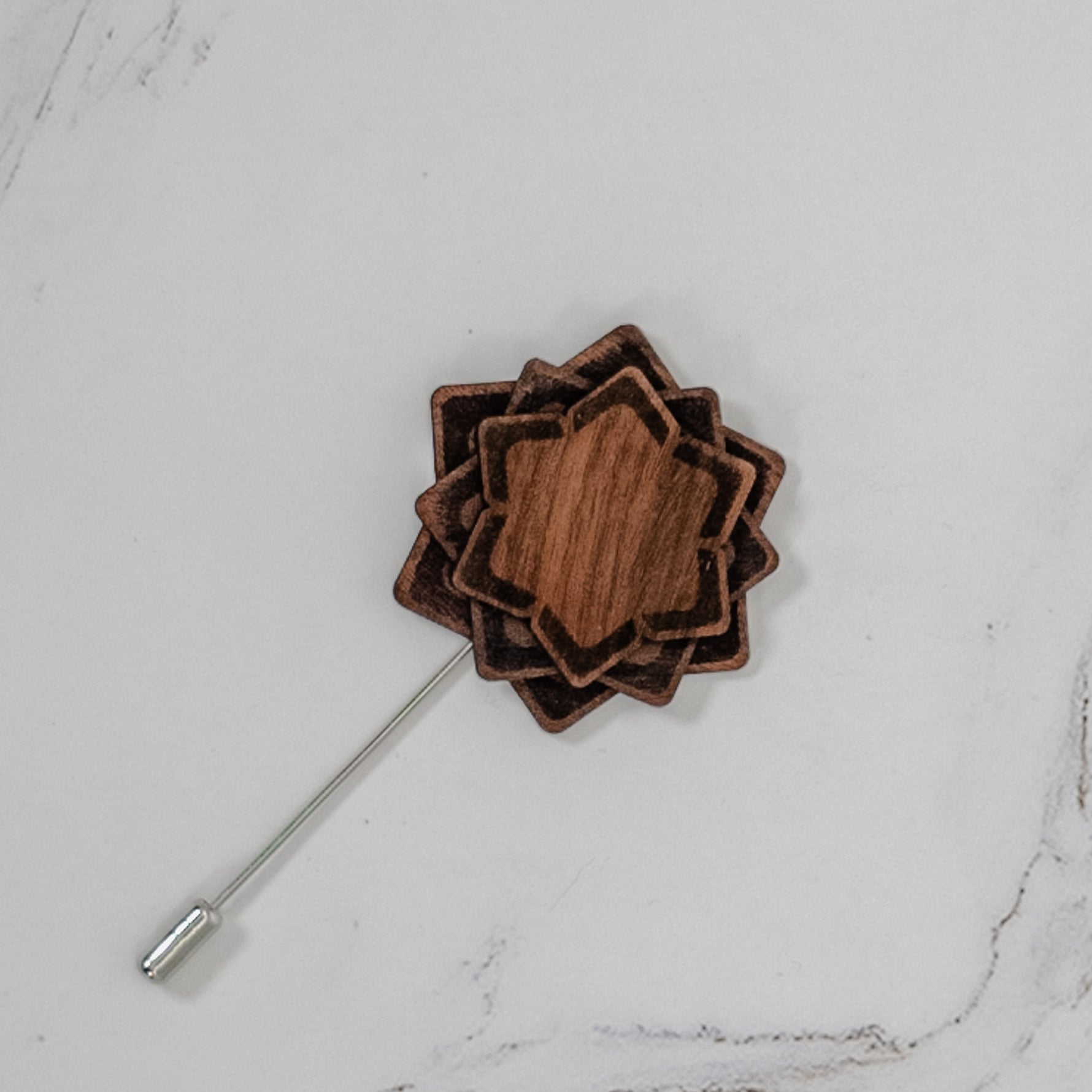 Wooden lapel pin on a marble surface