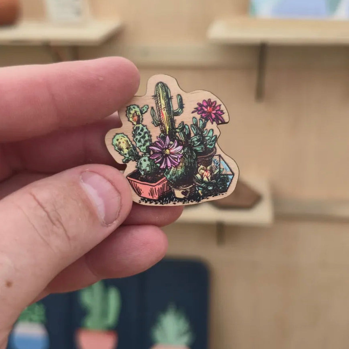 Cactus and succulent garden cherry wood magnet shown in hand