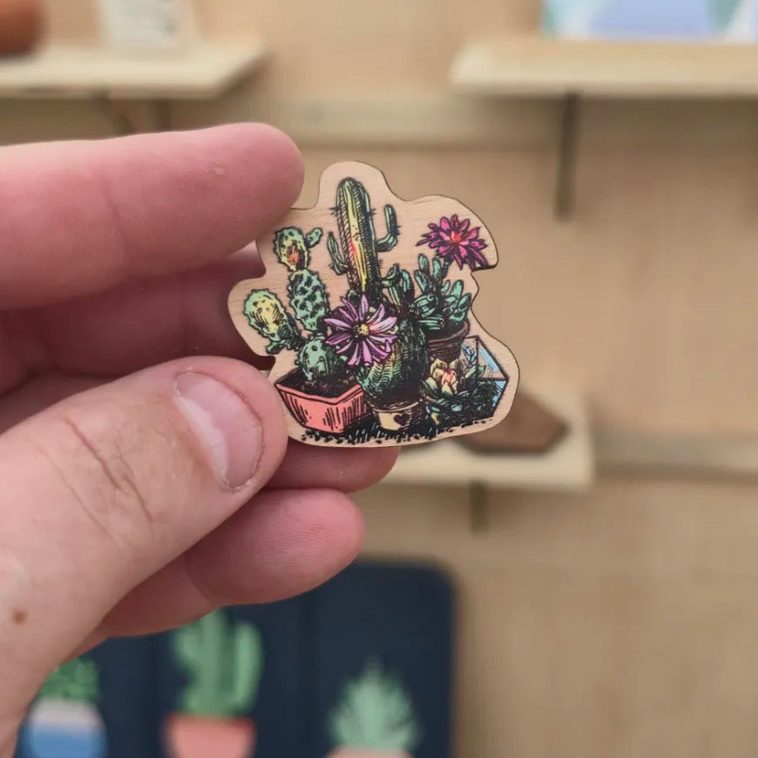 Cactus and succulent garden cherry wood magnet shown in hand