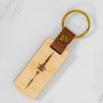 Maple wood keychain engraved with a personalized audio sound wave, mounted on a brown leather strap with brass ring, custom made by PRWMade