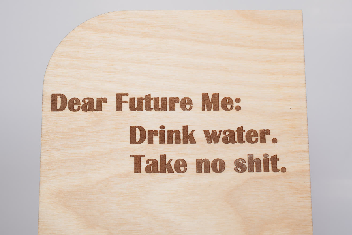 Close-up of the engraved Dear Future Me lettering on a wooden message board, showing crisp laser engraving on wood grain
