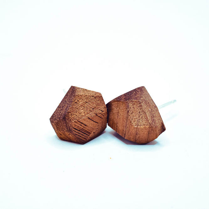Handcrafted geometric wood stud earrings with ½″ faceted surfaces, natural finish, and sterling silver posts on white background.