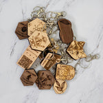 The No Hate Trail arch keychain shown alongside the full PRWMade wooden keychain collection in maple and walnut