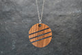 Round wood and stone inlay pendant in Walnut with crushed Lapis Lazuli, sterling silver chain