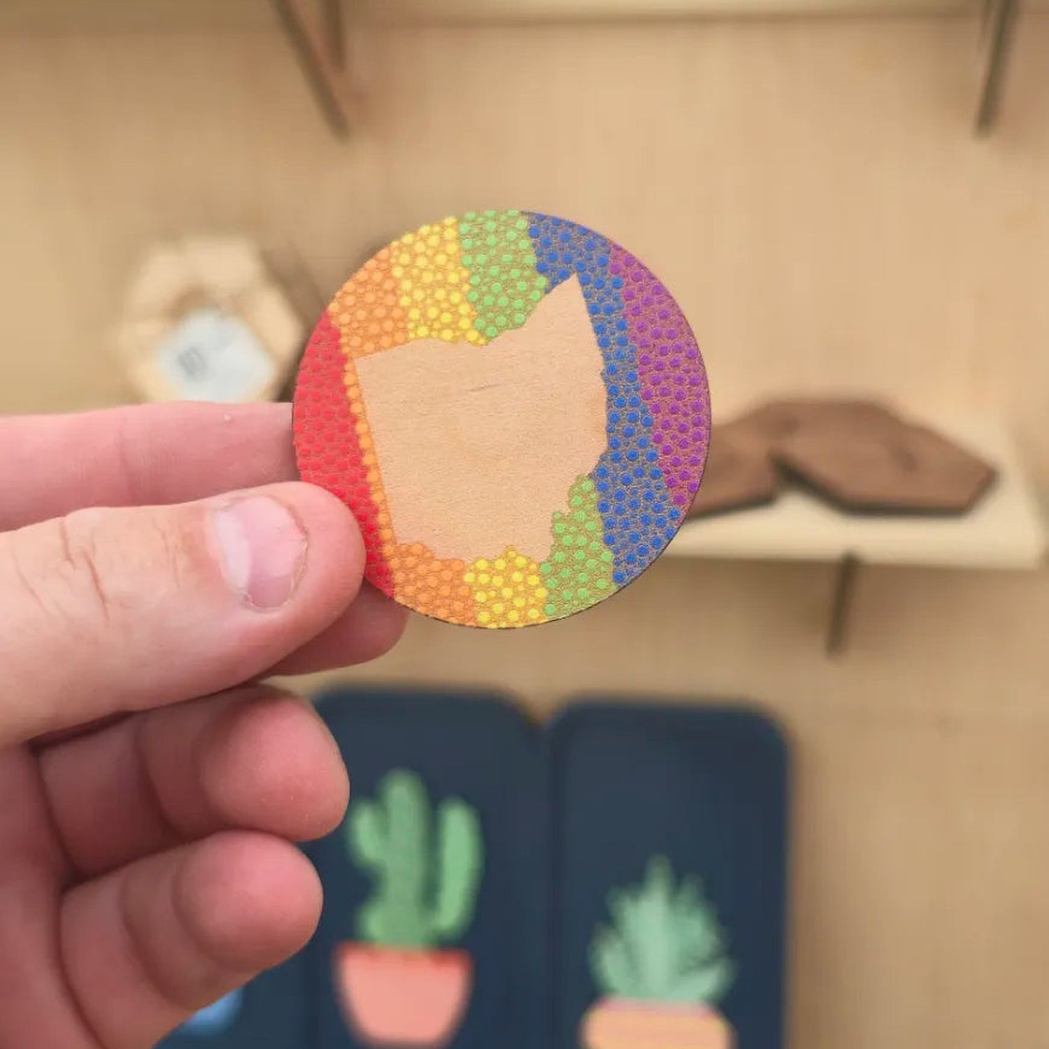 Ohio rainbow pride border cherry wood magnet shown in hand