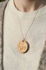 Custom star-chart maple necklace, worn on cream cardigan