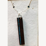 Wenge bar pendant with a vein of crushed turquoise inlay along one long edge, hanging from a sterling silver chain on a white seed-paper display card