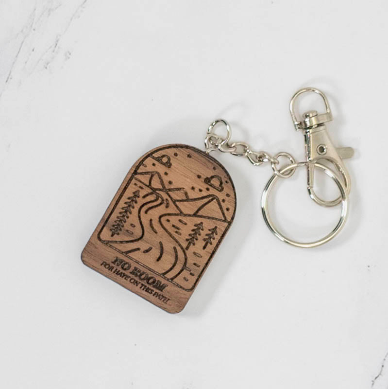 Walnut arch wood keychain laser engraved with a mountain, pine trees and trail scene, dark grain with silver hardware, by PRWMade