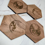 Walnut moon phase coaster set angled on marble, waxing crescent and full moon engravings
