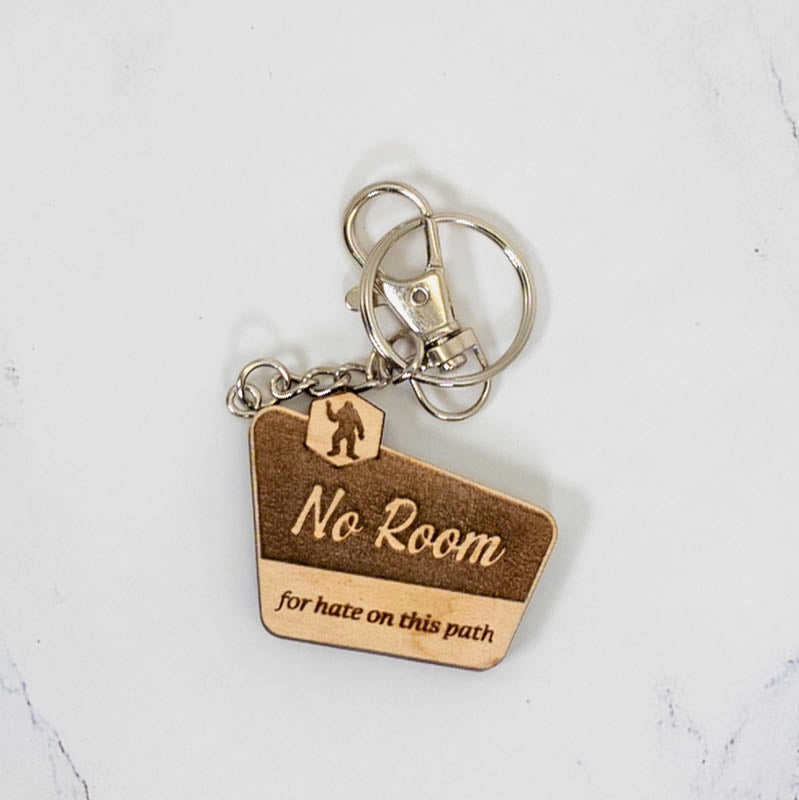 Walnut wood keychain shaped like a trail marker sign, engraved No Room For Hate On This Path with a Bigfoot silhouette, handmade by PRWMade