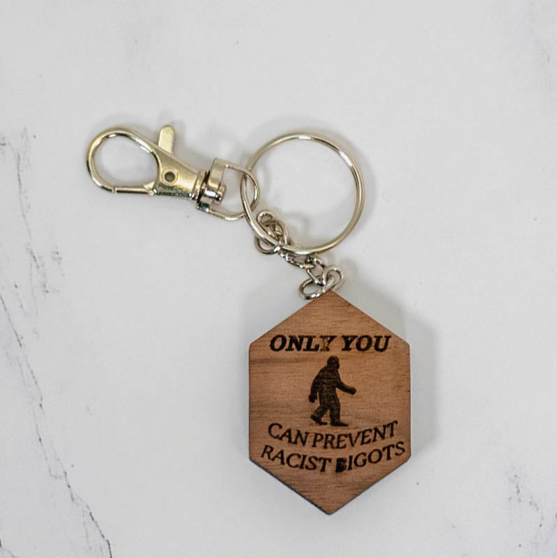 Walnut hexagon wood keychain engraved with a full Bigfoot silhouette and the words Only You Can Prevent Racist Bigots, silver clasp, by PRWMade